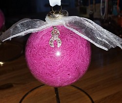 Clear glass ornament filled with pink mesh fabric.