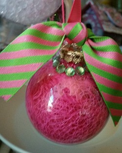 This clear glass ornament is filled with pink mesh.