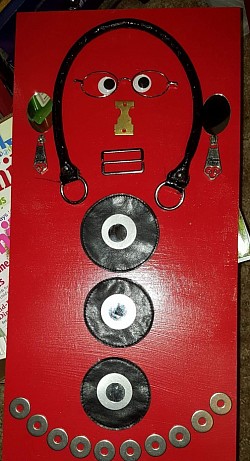 leather parts from.a purse..stainless washers..mirrors..belt buckle..zipper pulls on painted red piece of wood. Unfinished