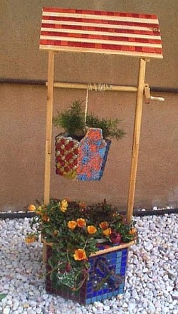 Wishing well out back with mosaic designs .