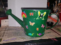 Painted and decoupaged watering can used for a planter.